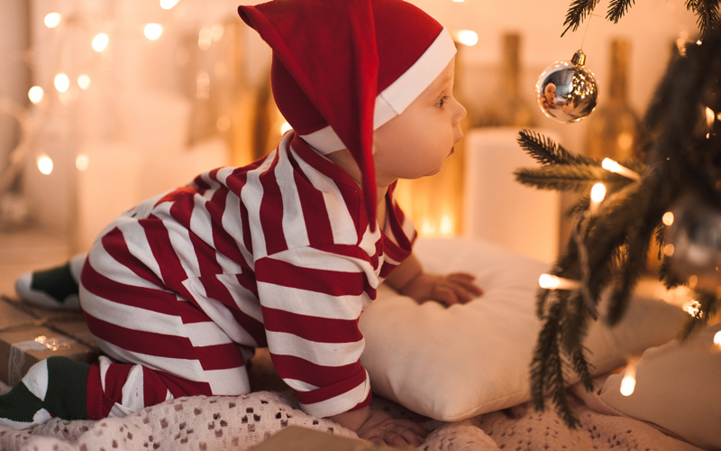 Kisbaba a karácsonyfa mellett