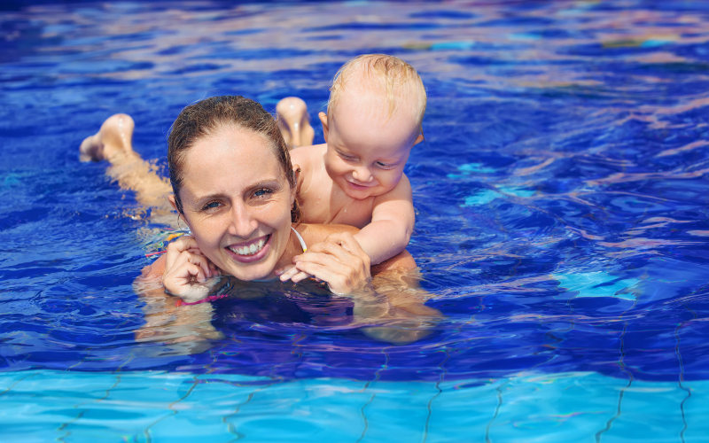 Édesanya gyermekével a medencében